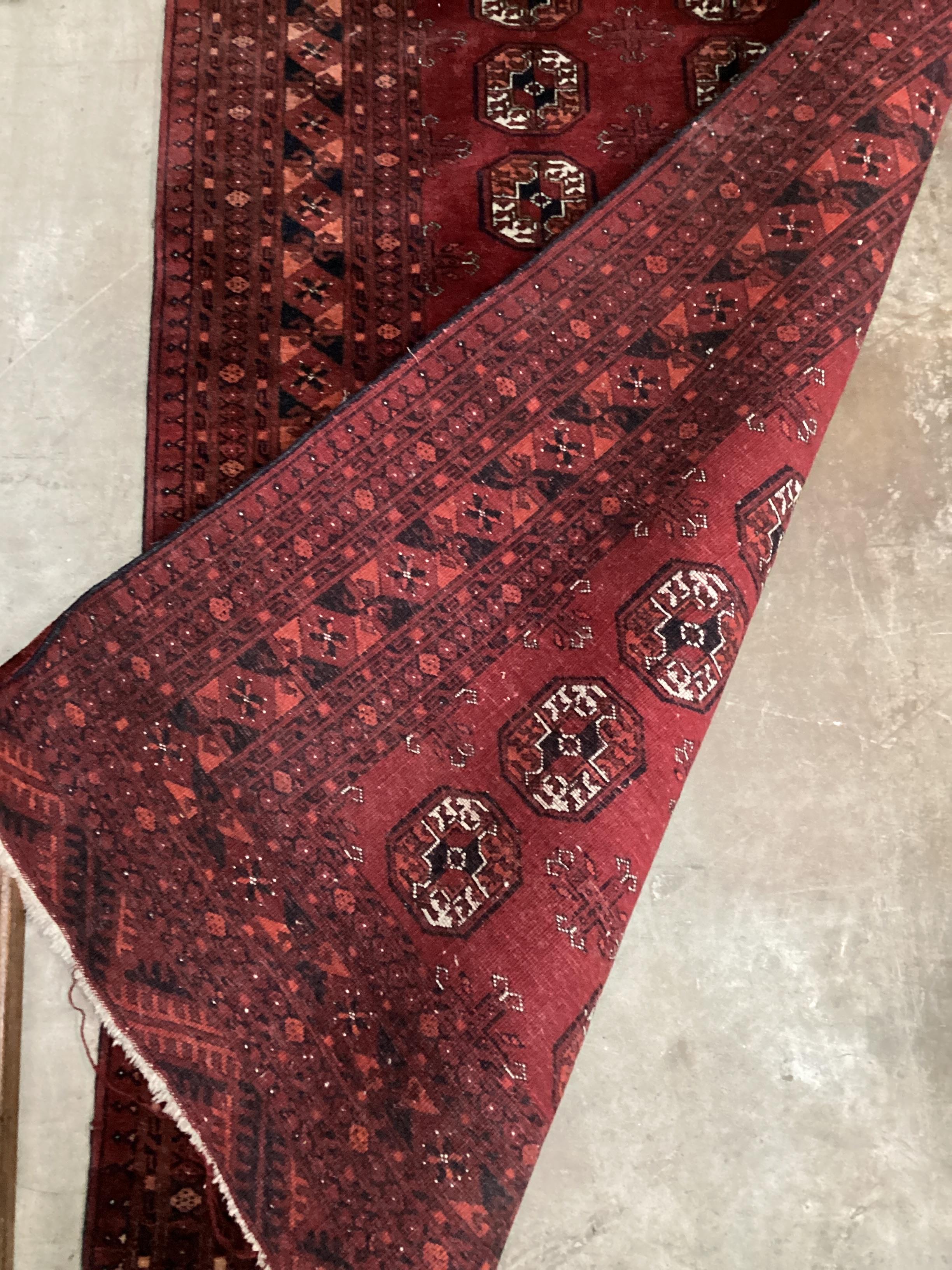 A Bokhara red ground rug, 188 x 104cm
